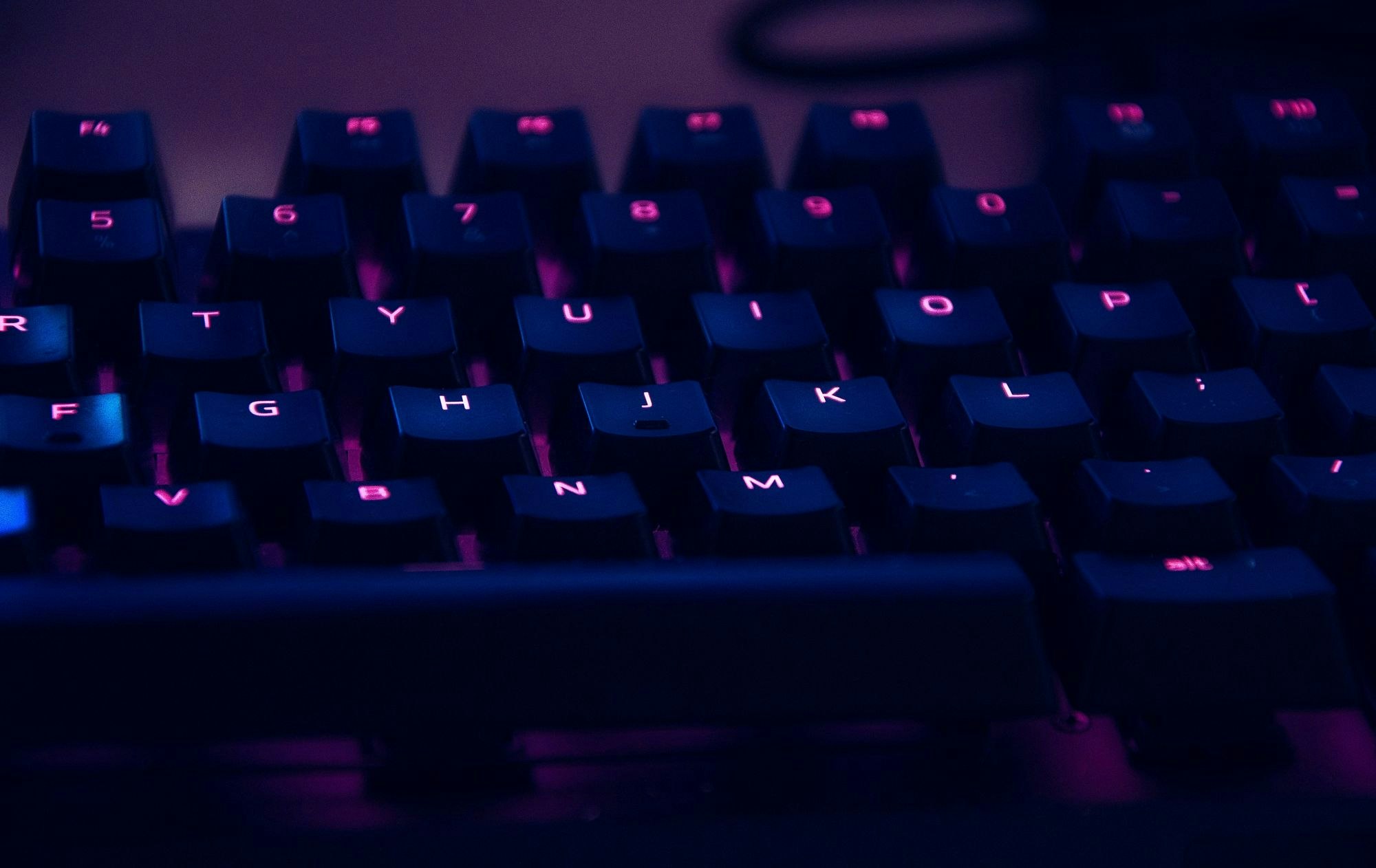 keyboard for computer with purple light in the background