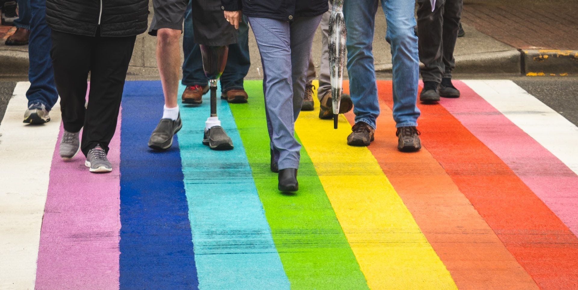 People walking across rainbow crossing