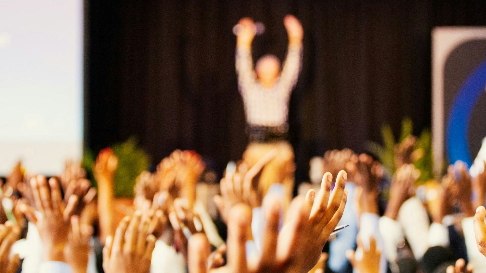 attendees with hands up at event