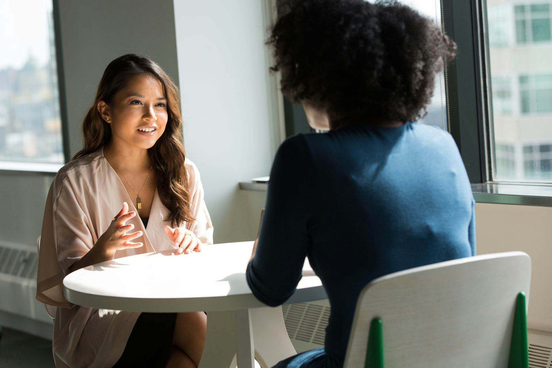 two women talking at table