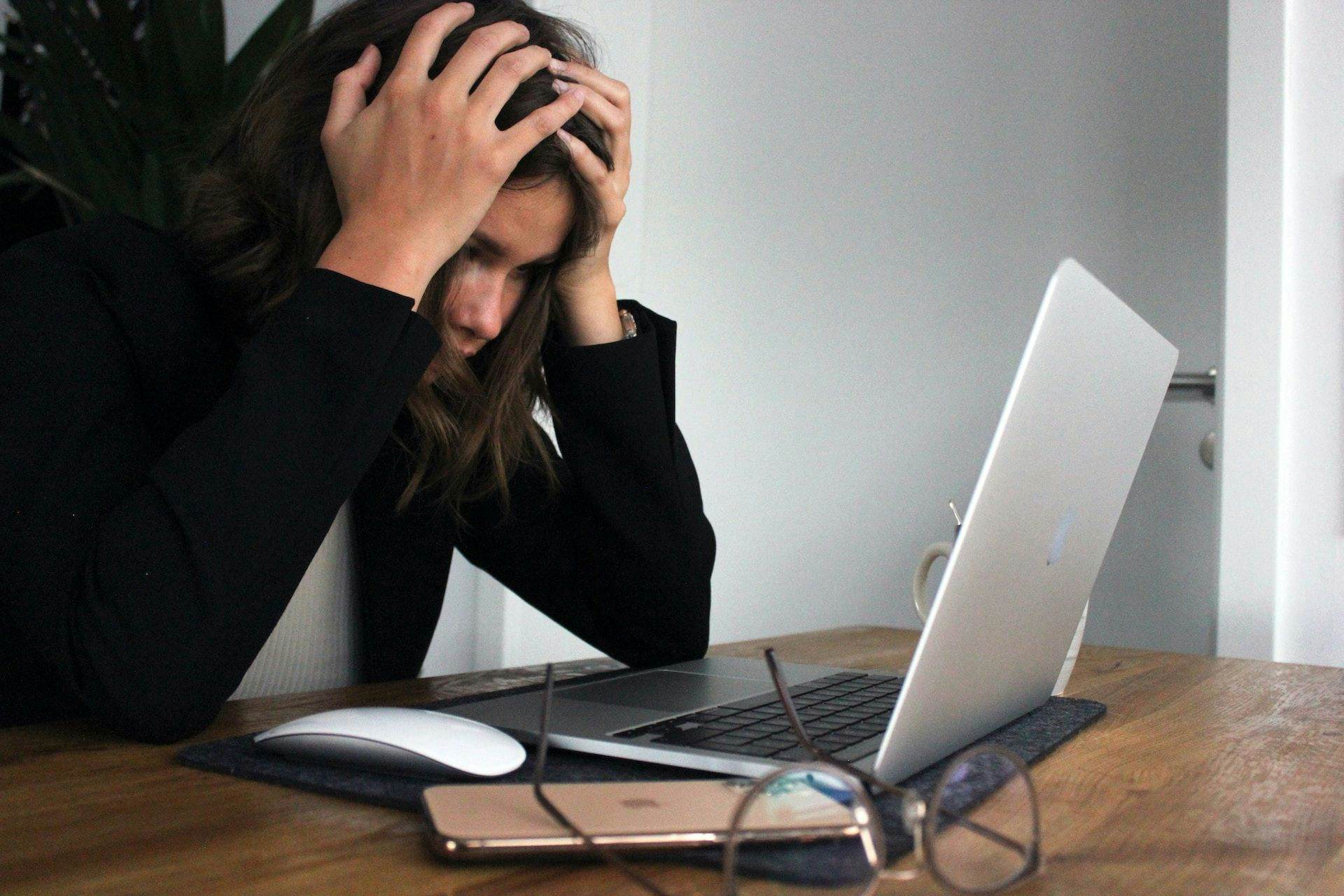 woman looking stressed at laptop