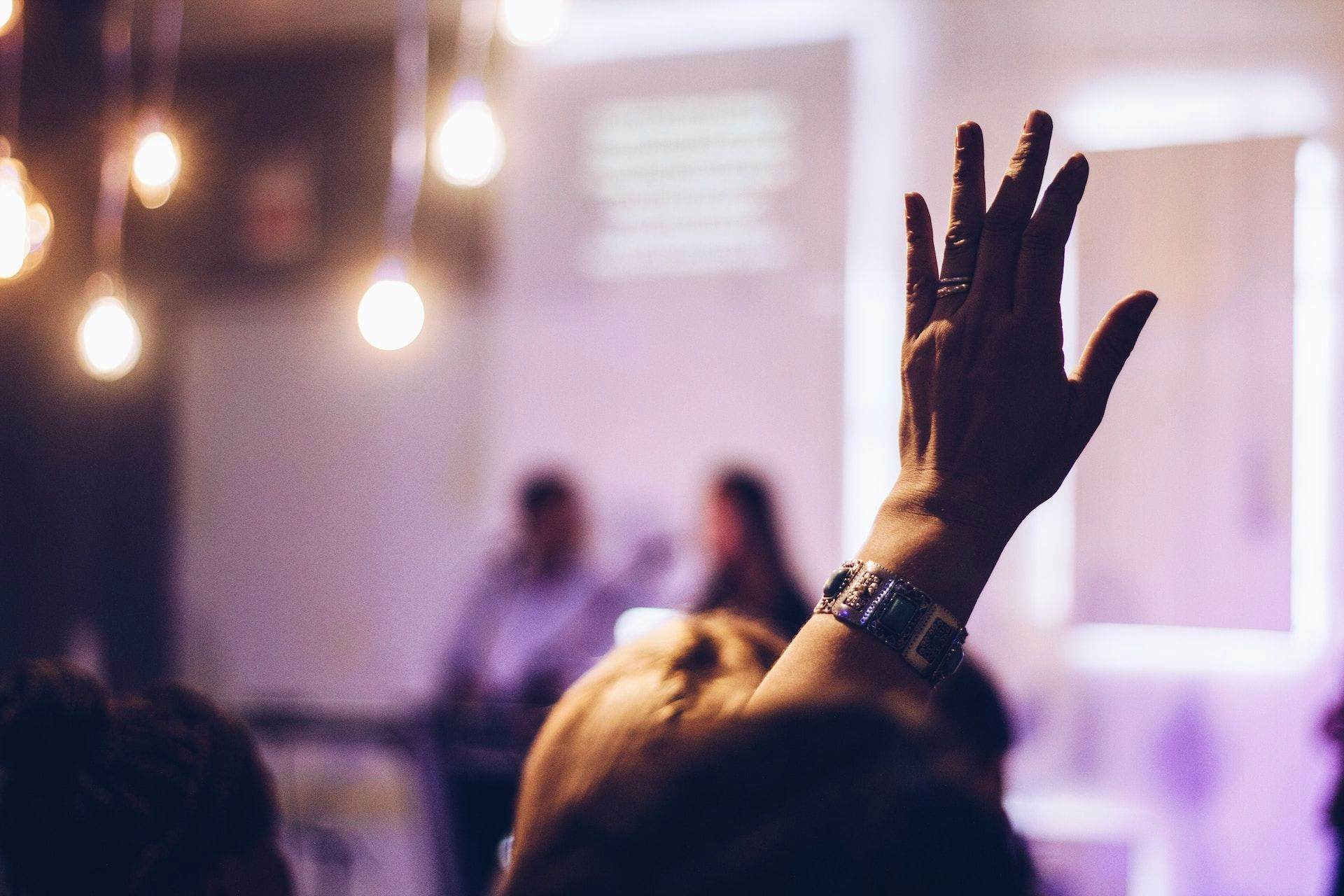 audience member with hand up at event