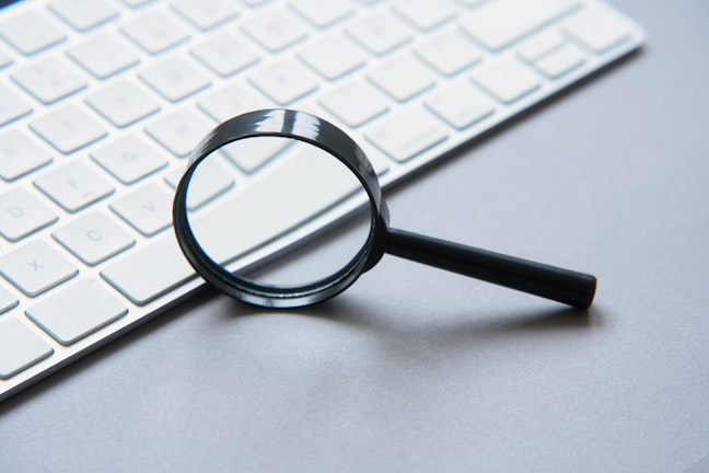 Magnifying glass leaning on keyboard