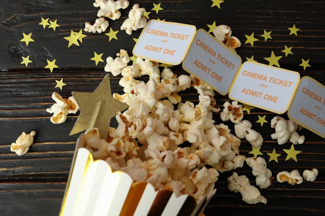 Popcorn with cinema tickets and gold star confetti
