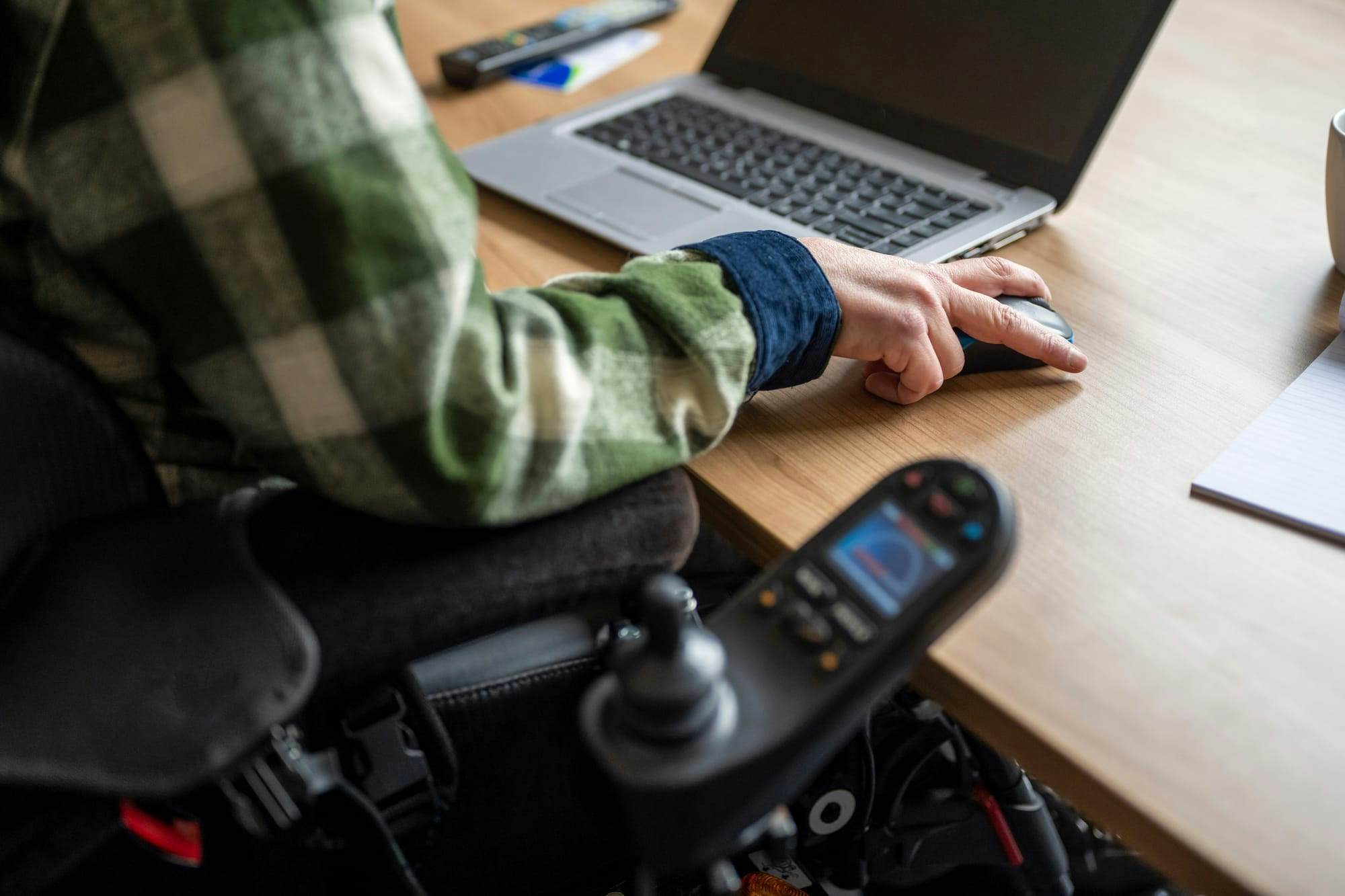 disabled person sitting at desk in wheelchair on laptop