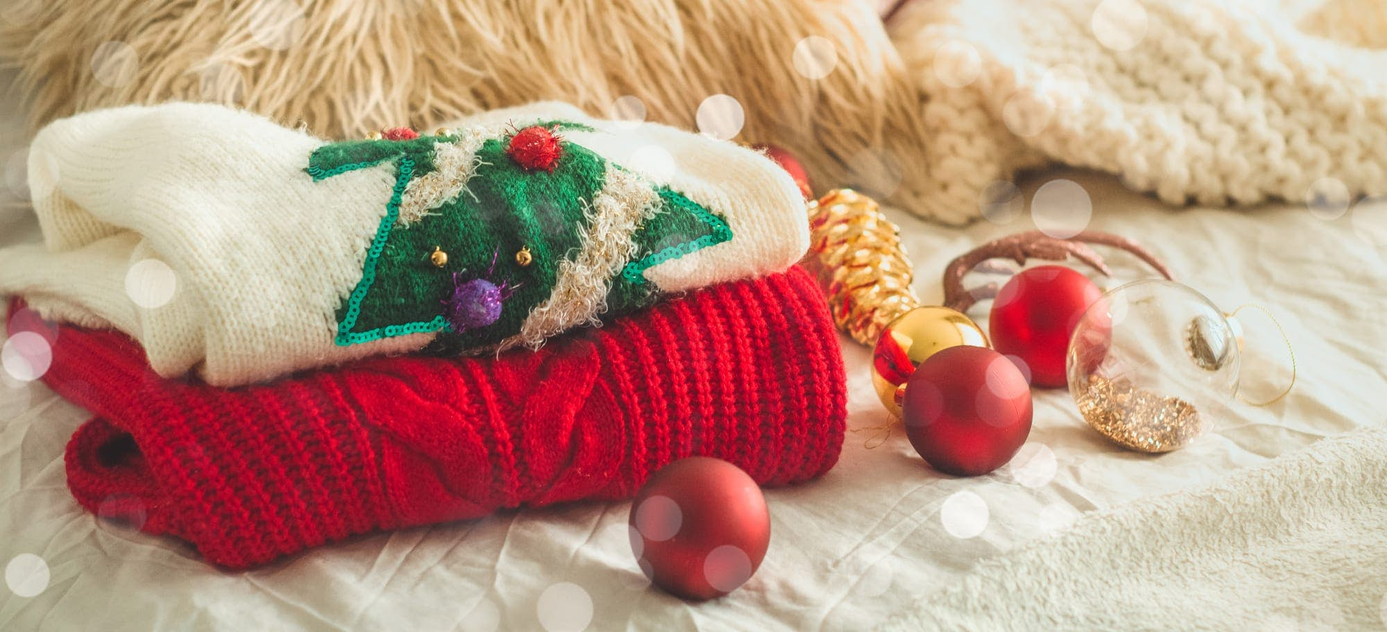 christmas jumpers folded with baubles around